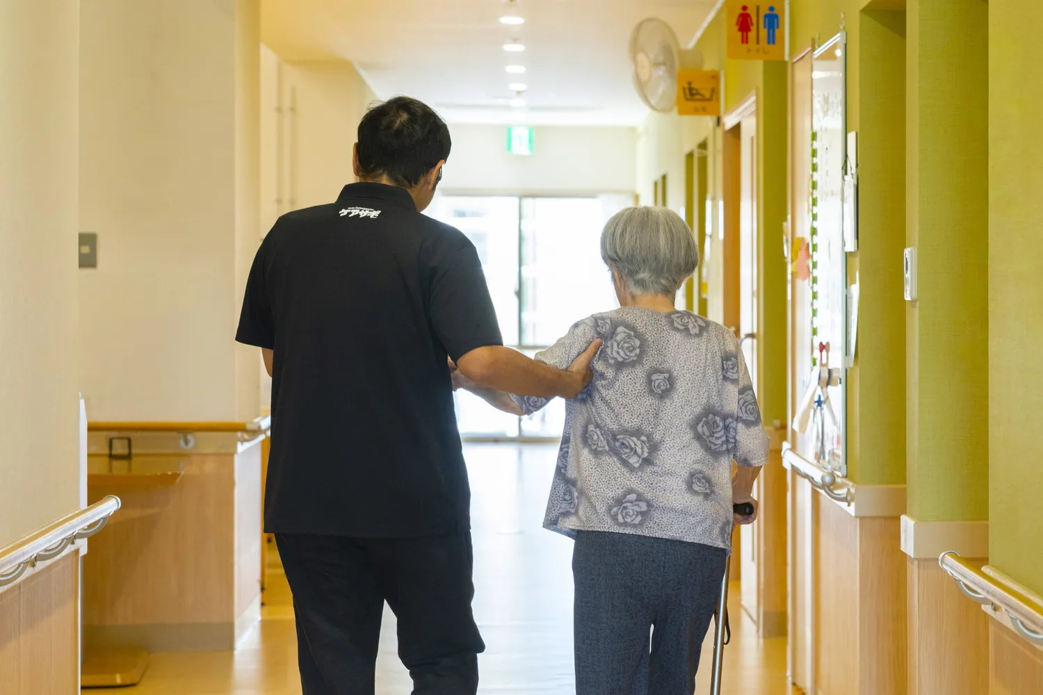 廊下でご利用者様の歩行を介助するスタッフ