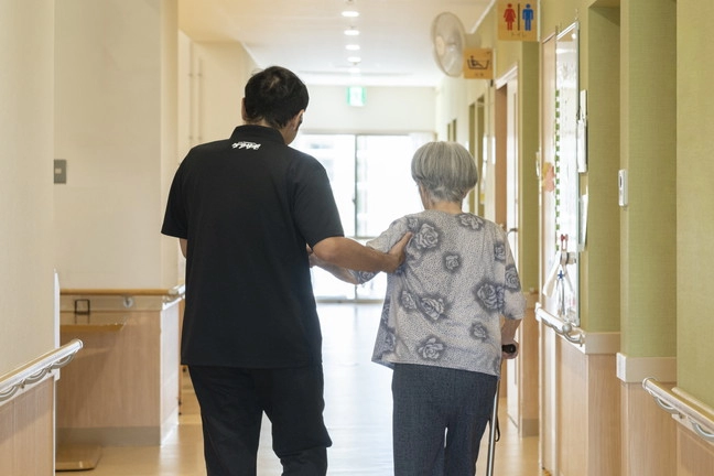 スタッフが歩行を介助するご利用者様の様子