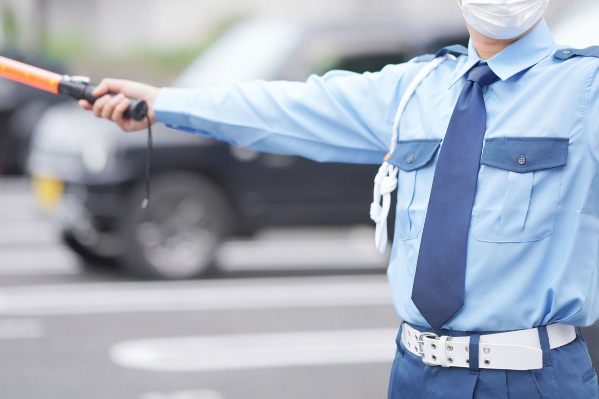 施設前で立哨する制服姿の警備員