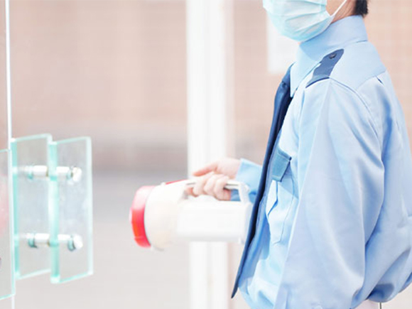 赤い誘導棒を構える警備員