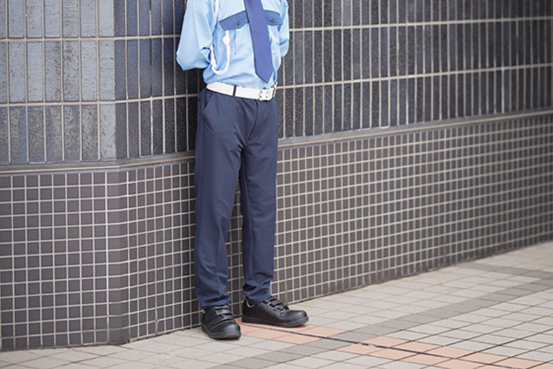 壁にもたれかかる警備員