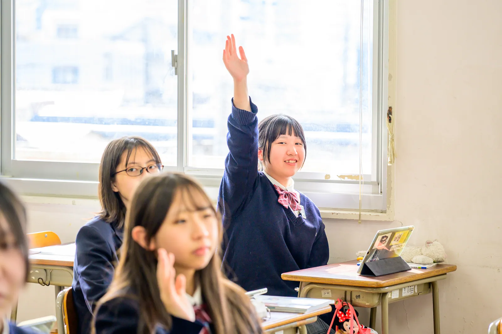 教室で手を挙げる生徒