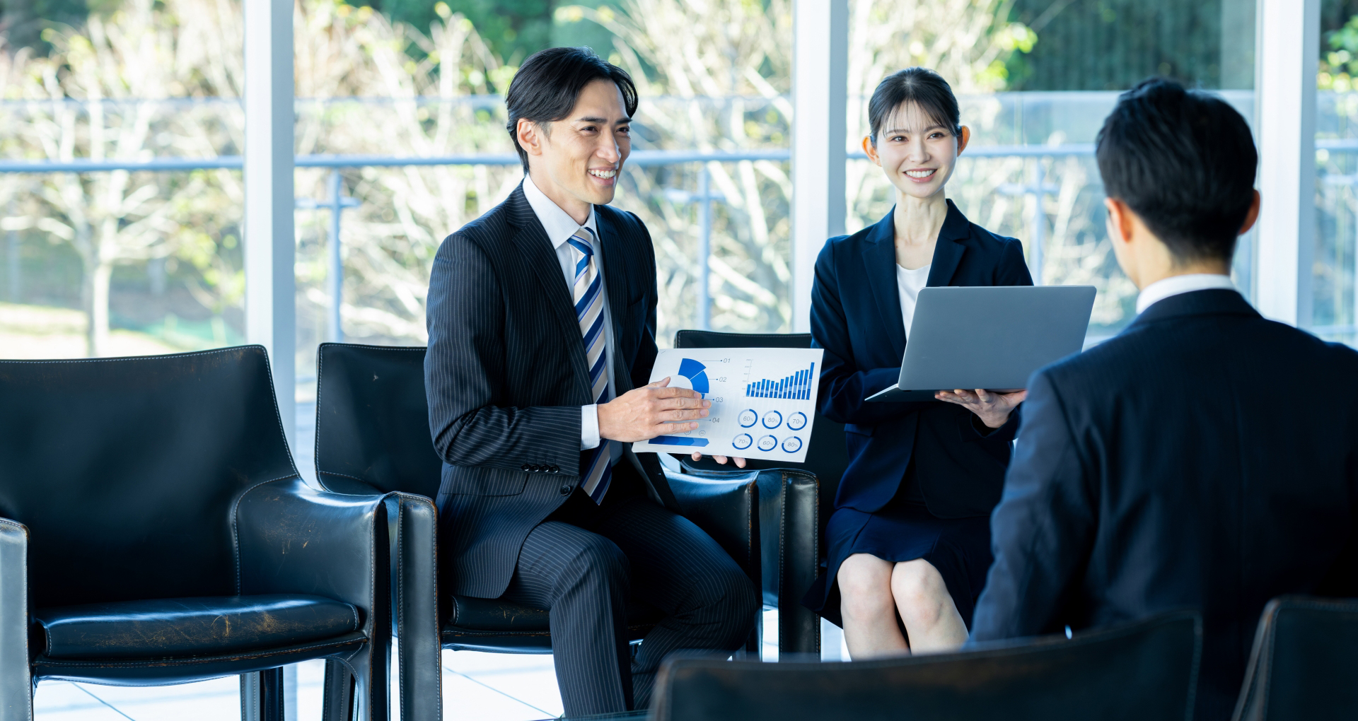 オフィスでスーツを着たビジネスマンとビジネスウーマンがクライアントにプレゼンテーションをしている様子