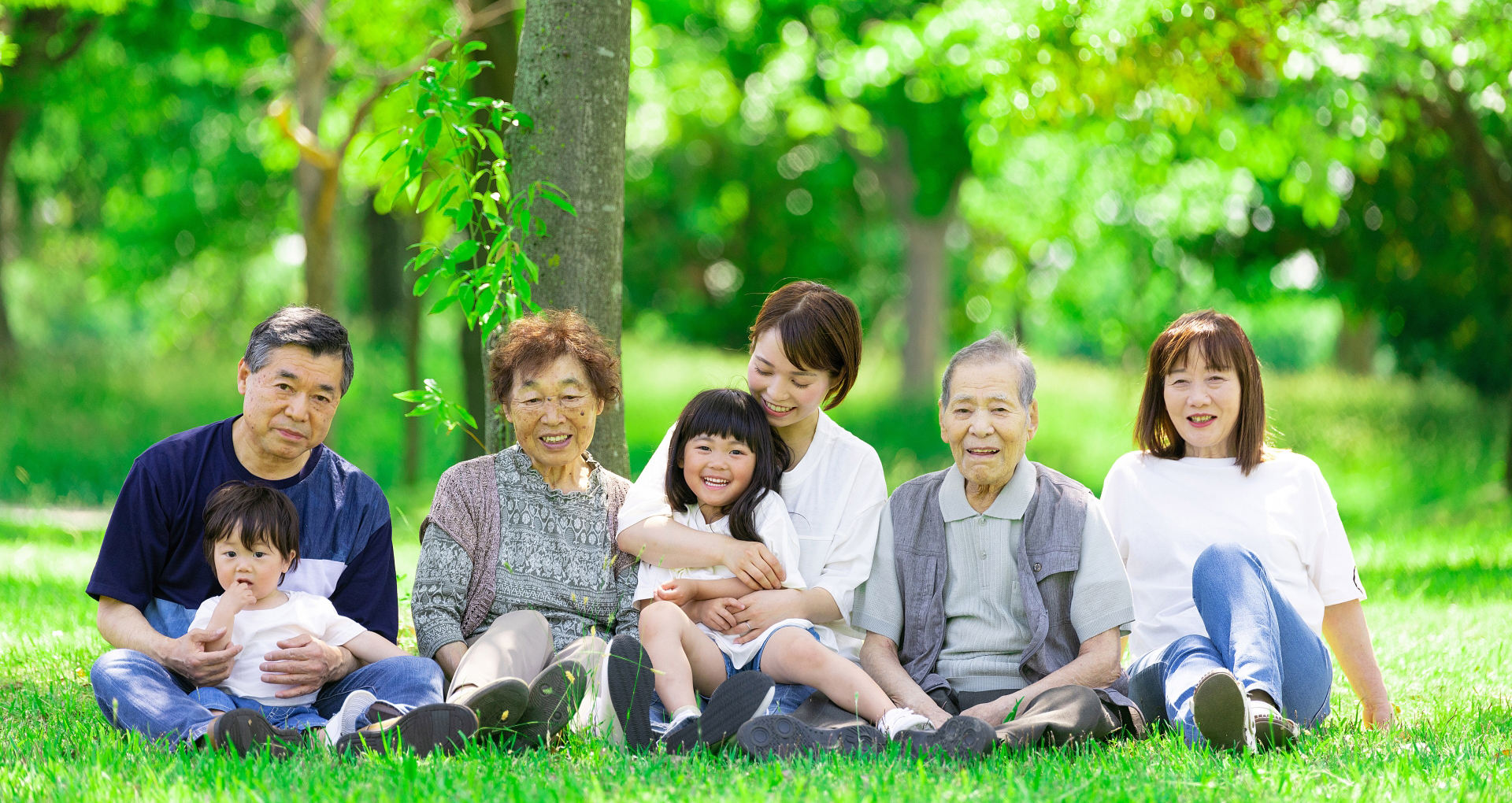 ビジネスミーティング中の4人のビジネスパーソンがノートパソコンと資料を見ながら話し合っている様子