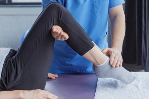 ベッドでリハビリを受ける人と医学療法士