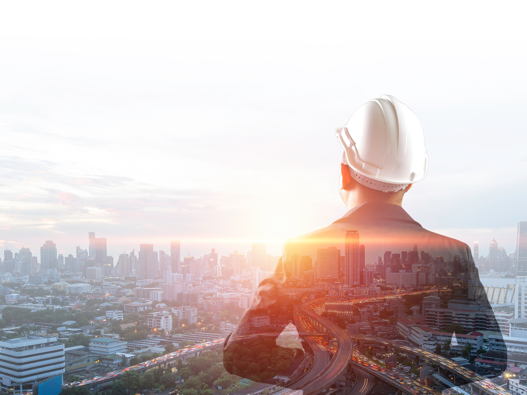 都市を見渡す建設作業員の後ろ姿