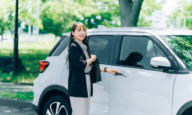 在租車前微笑開車門的女性