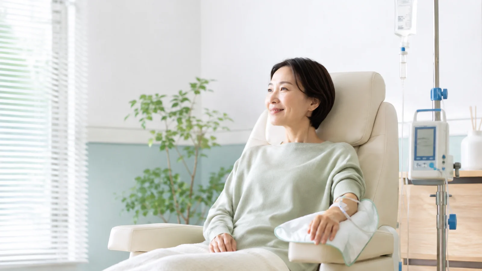 明るい診療室で点滴療法を受ける女性