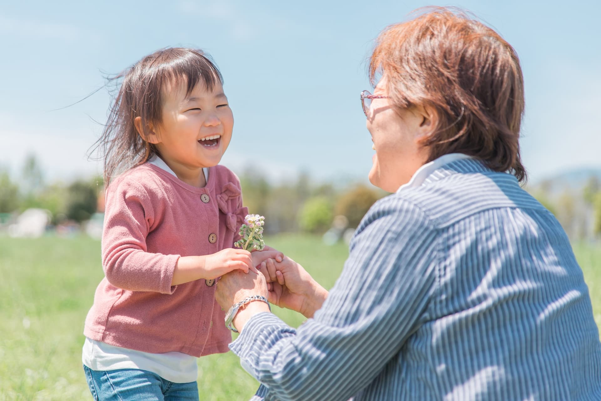 祖母に花を渡す子ども