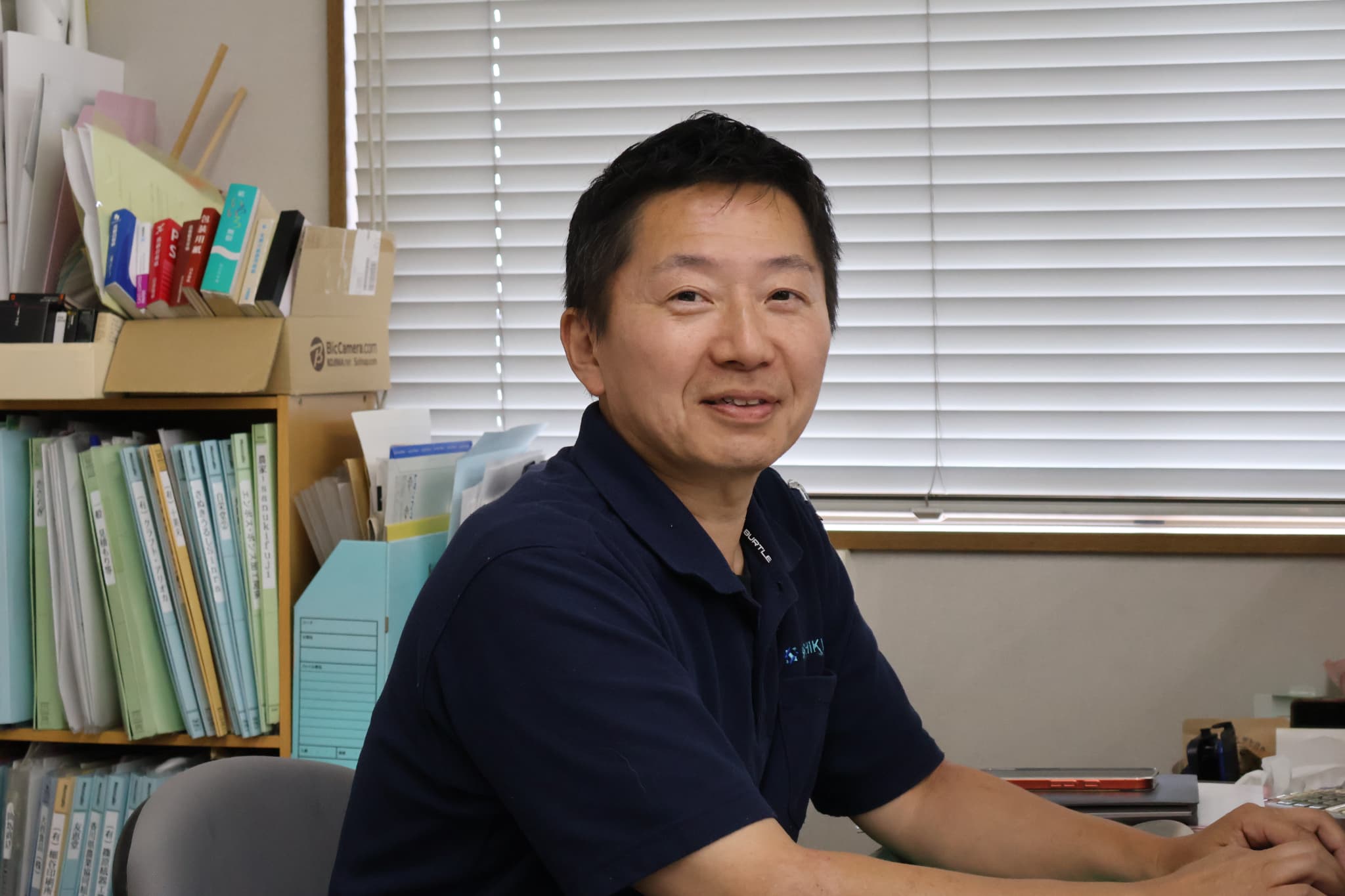 デスクで笑顔を見せる社員