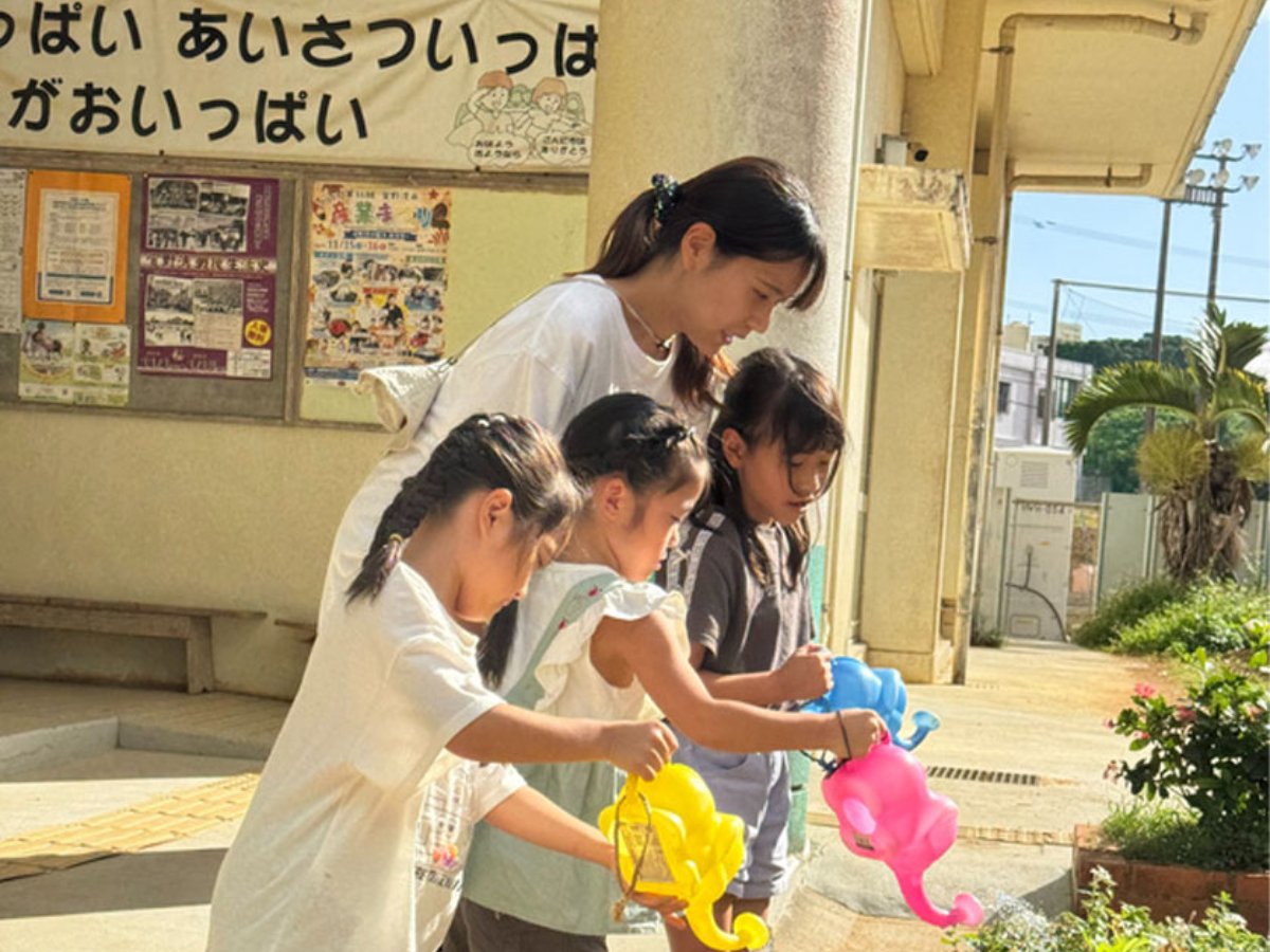 職員と一緒に花に水をあげる子どもたち