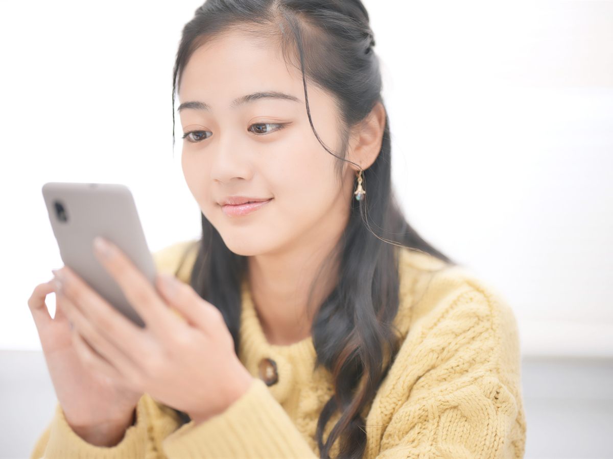 スマートフォンの状態を確認する女性