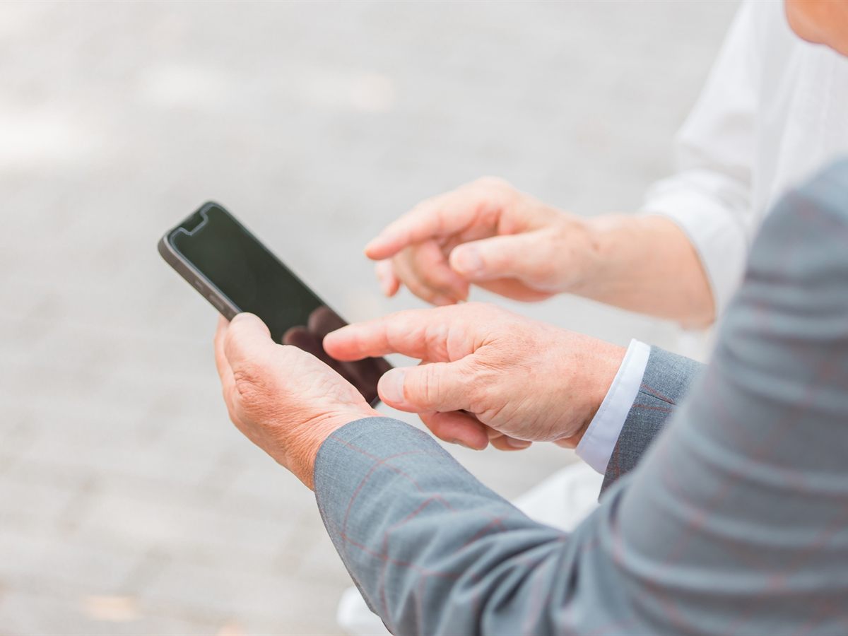スマートフォンの操作を手伝うスタッフの手元