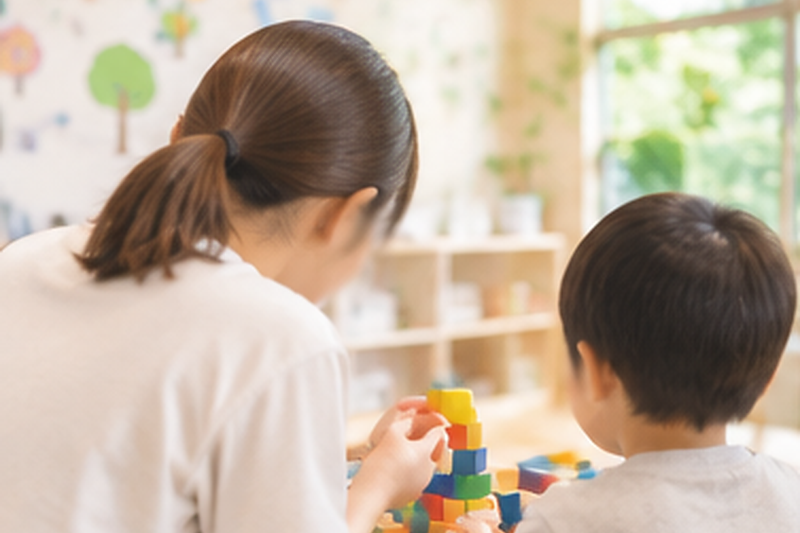 積み木で遊ぶ子どもと支援員