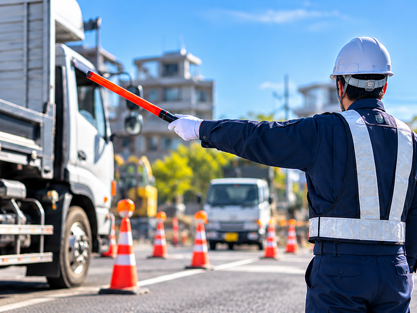 トラックを誘導する警備員