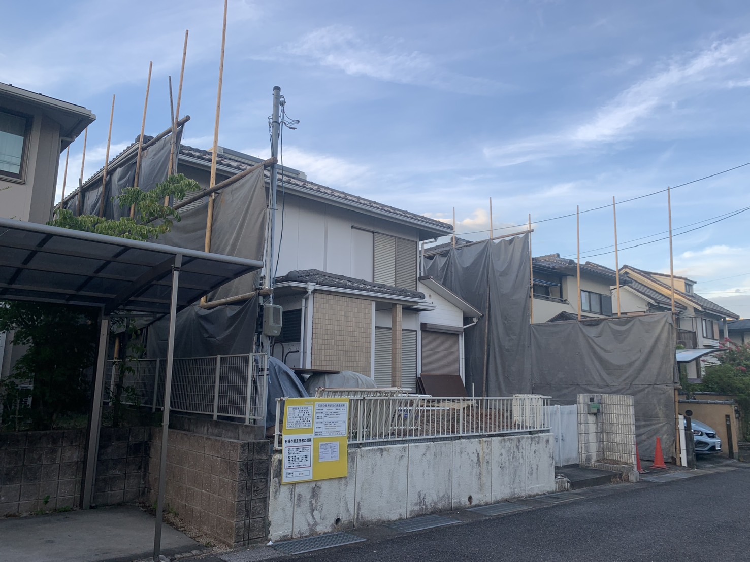 足場と養生シートを設置した解体前の住宅