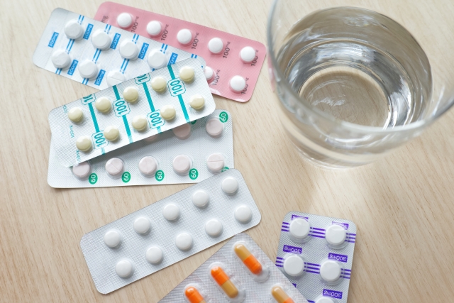 テーブルに並んだ錠剤と水の入ったグラス