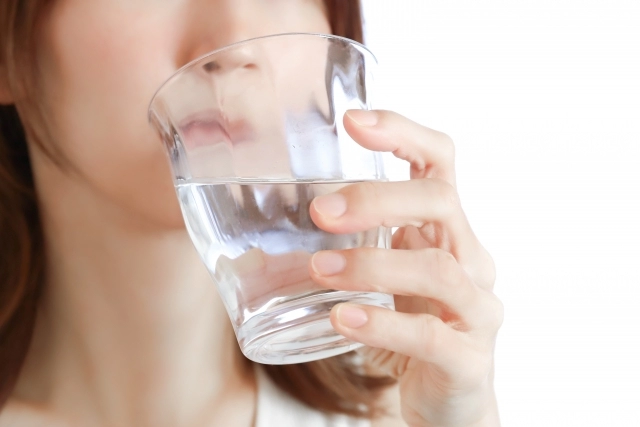 グラスの水を飲む女性
