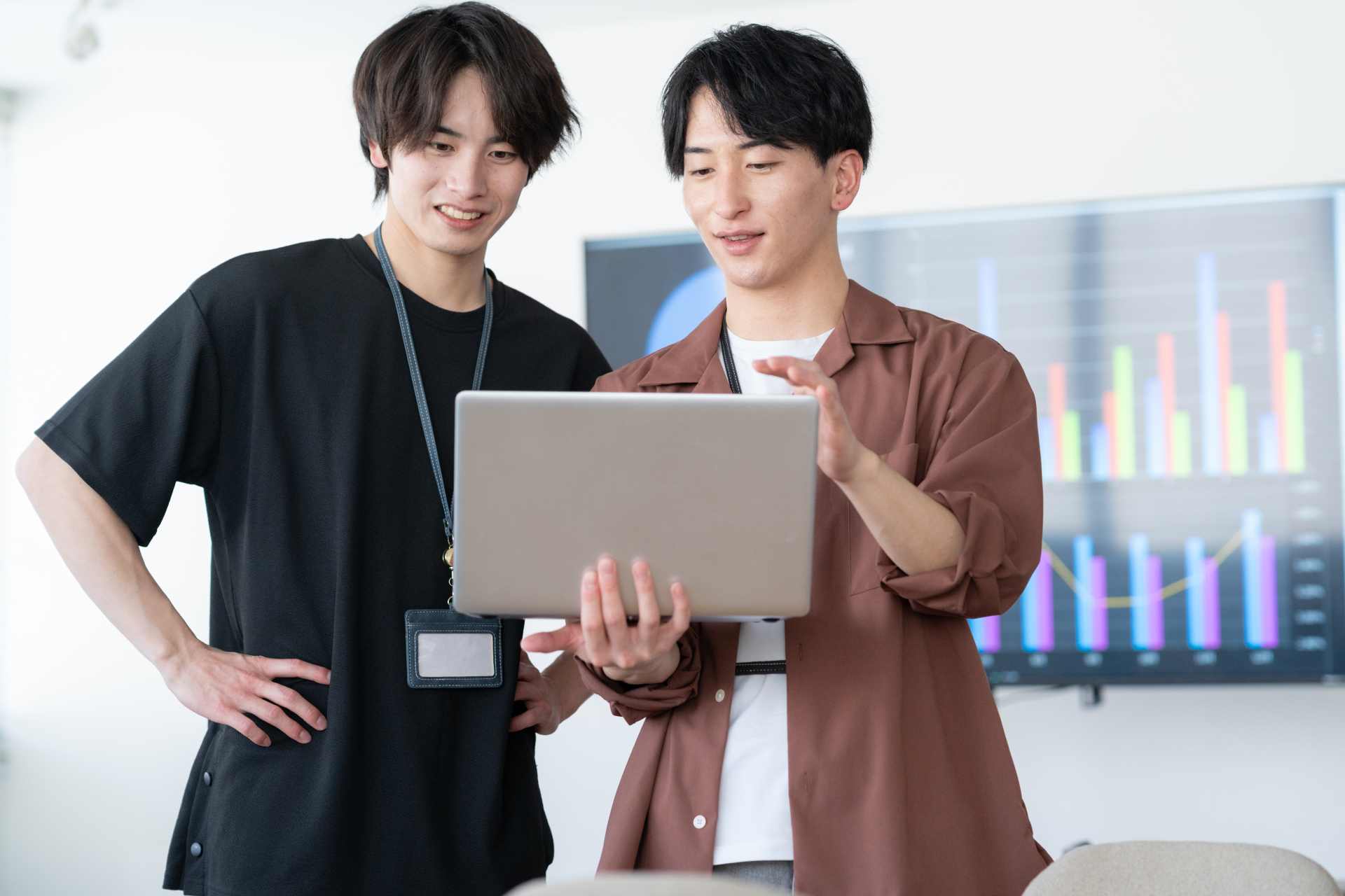 ノートPCを見ながら相談するスタッフ