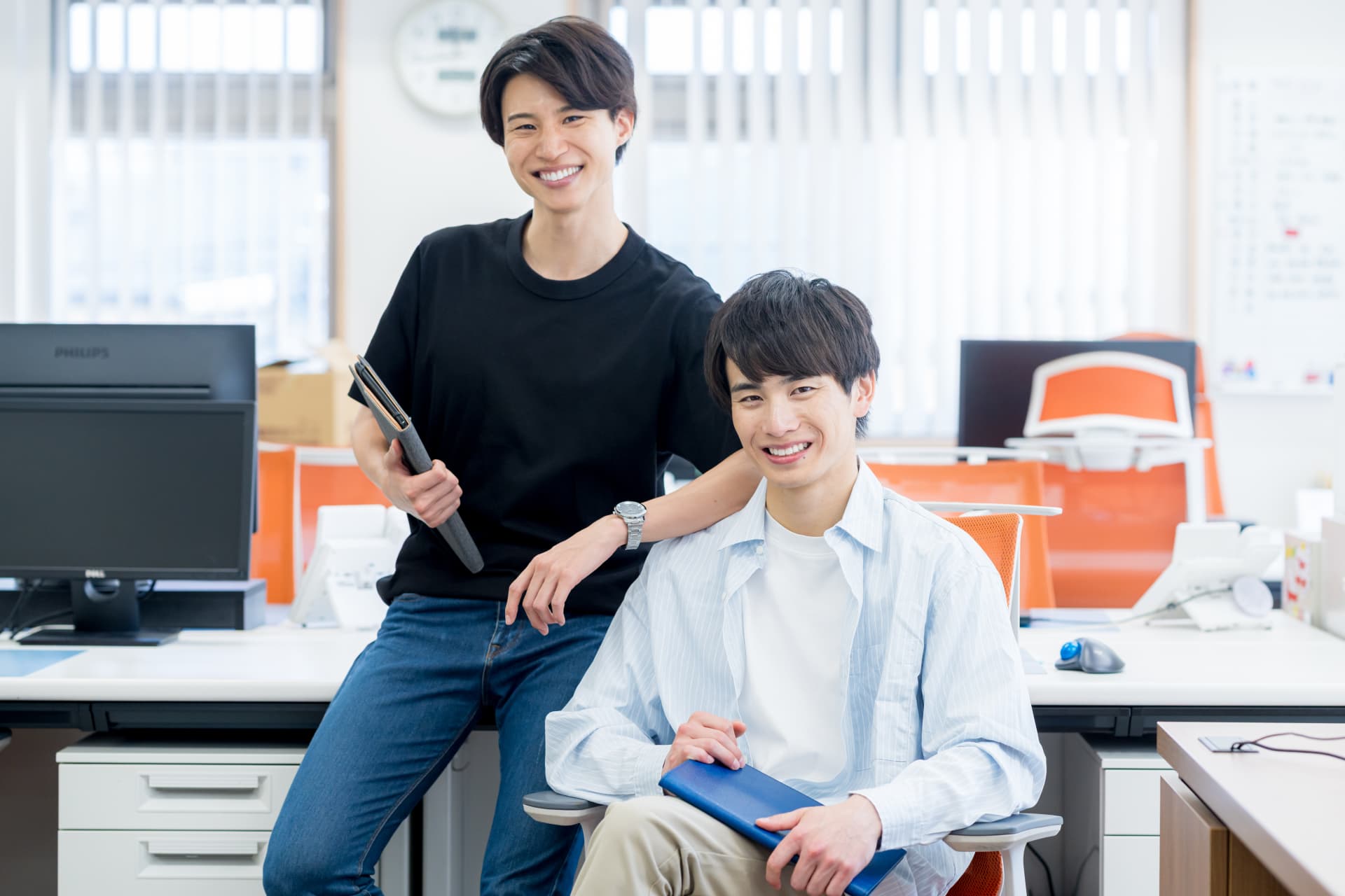 オフィスで笑う2人のスタッフ
